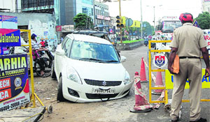 A car got stuck on the road, a part of which caved in near Football Chowk in Jalandhar on Thursday. 
