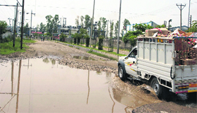 A loaded vehicle being driven through a waterlogged area in the Industrial Area at Samba.