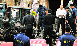 Policemen examine the scene of a blast near the BJP office at Dilsukhnagar in Hyderabad in February 2013