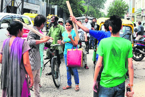 A girl looks on in fear as youths wielding sticks attack commuters in Ludhiana on Thursday.