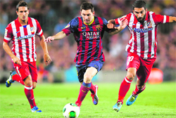 Barcelonas Lionel Messi and Atletico Madrids Arda Turan (right) battle for the ball during their Spanish Super Cup second leg match at Camp Nou stadium in Barcelona on Wednesday.  Reuters