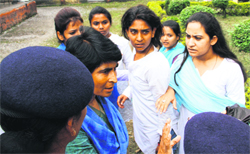 Policewomen and college staff pacify two warring group of girls during polling for 
