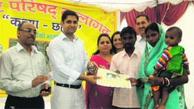 Parents of a girl child receive a fixed deposit receipt of Rs 1,100 from SDM Yunus Khan at Nalagarh on Friday.