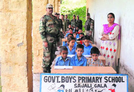 Students pose for a photograph with Army personnel in Kalakote on Friday. 
