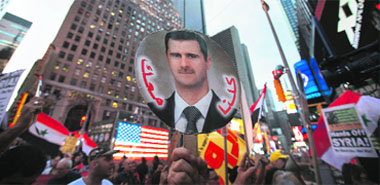 Supporters of Syrian President Bashar al-Assad hold up his image at an anti-war rally at Times Square in New York. 