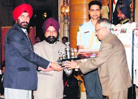 Prof Ajaib Singh Brar (centre), Vice-Chancellor of the Guru Nanak Dev University, Amritsar, along with Dr HS Randhawa, Deputy Director Sports (left) of the university, receives Maulana Abul Kalam Azad (MAKA) Trophy for the year 2010-11 from President Pranab Mukherjee at Rashtrapati Bhawan in New Delhi on Saturday