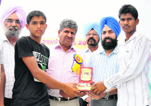 Chief Parliamentary Secretary Sarup Chand Singla honouring students at the concluding ceremony of the 59th School Sports Championship in Bathinda on Saturday. 