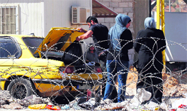 Syrians undergo security checks as they cross the Masnaa border post between Syria and Lebanon on Saturday.