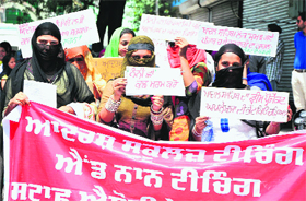 Protesters hold placards carrying slogans against the state government.
