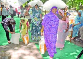 The beneficiaries of the scheme carry subsidized foodgrain at Lakshmi Bai Nagar in New Delhi on Sunday
