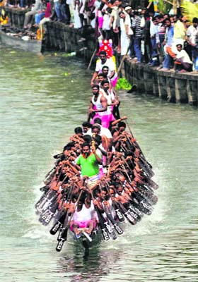 People take part in a snake boat race in Kochis Champakkara backwaters on Sunday