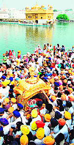 Devotees take out a procession on the occasion of 409th installation anniversary of Guru Granth Sahib at the Golden Temple in Amritsar on Sunday