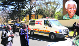 Members of the South African Police guard the ambulance carrying anti-apartheid leader Nelson Mandela (inset) in Johannesburg on Sunday.