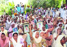 Family members of the farmers, who committed suicide owing to debt, stage a dharna against the state government, outside the District Administrative Complex in Bathinda on Monday