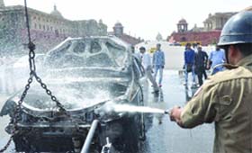 A car parked at a high-security area near Rashtrapati Bhavan caught fire. No casualties have been reported. A fireman dousing the flames at Vijay Chowk in New Delhi on Monday