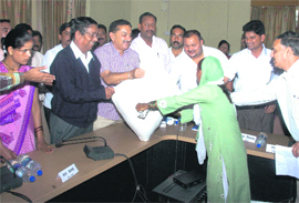 Three Congress legislators from Pithoragarh district hand out a ration bag. 