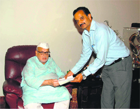 Prof H. K. Dhami, Acting Vice-Chancellor of Kumaon University, presents a cheque for disaster relief to Uttarakhand Governor Aziz Qureshi on Monday.