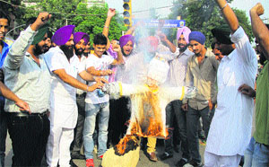 Youth Akali Dal activists burn an effigy protesting against the frequent hike in petrol and diesel prices in Jalandhar on Monday