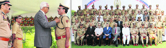 Governor NN Vohra honours DIG (Traffic) Shafaqat Watali during the police investiture ceremony at Raj Bhawan; and (right) the Governor, Chief Minister Omar Abdullah, Deputy Chief Minister Tara Chand and other top police officers pose with awardees at the presentation of Presidents Medal for Meritorious Services at Raj Bhawan in Srinagar on Monday.