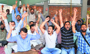 Jammu and Kashmir Urban Local Bodies employees shout slogans in support of their demands in Srinagar on Monday.
