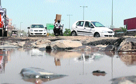 In the absence of repair and maintenance, commuters face an uphill task to negotiate the potholed service lane of the National Highway No 8 at Hero Honda Chowk in Gurgaon on Tuesday.