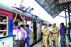 Passengers try to enter a jampacked coach of a train at the Anantnag railway station on Tuesday.