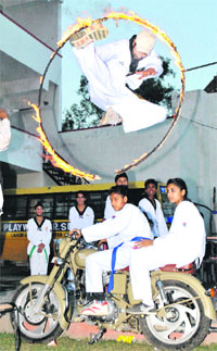A taekwondo coach jumps through a fire ring on the eve of World Taekwondo Day in Patiala on Tuesday.