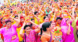 Women devotees carry Ganga jal in earthen pots prior to a religious ritual in Haridwar on Wednesday