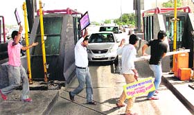 Free Passage: Villagers under the banner of the Samaj Vikas Samiti protest the poor condition of a stretch between Hero Honda Chowk and Kheriki Daula by allowing free passage to vehicles through the toll plaza on the Gurgaon-Delhi expressway for more than three hours on Wednesday