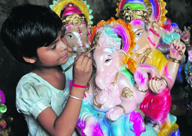 A girl adds colours to an idol of Lord Ganesha in Jammu on Wednesday. 