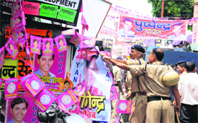 policemen remove posters and banners of candidates.