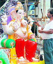 An artist gives final touches to an idol of Lord Ganesha ahead of Ganesh Chaturthi in Amritsar on Friday