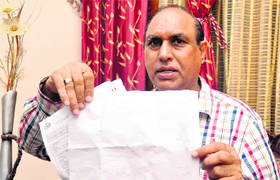 Krishan Kumar shows a reciept of the Aadhaar card at his residence in Sector 50, Chandigarh.