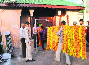 A  worker carries  garlands to the venue of Zubin Mehtas concert in Srinagar on Friday. 