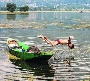 A boy jumps into the Dal Lake to beat the heat in Srinagar on Friday.