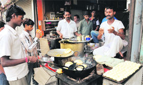 A helper fries puries for customers at Lachu Puriwalas shop.