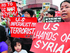 Protesters hold anti-US placards during a prayer in Manila on Saturday. 