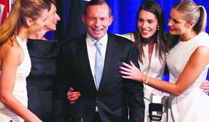 Tony Abbott stands with his wife (2nd L) and daughters as he claims victory in a function in Sydney on Saturday. 