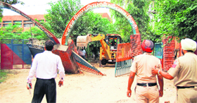 Officials oversee the demolition of an illegal structure at the SSP (Rural) office at Mall Mandi in Amritsar on Sunday.