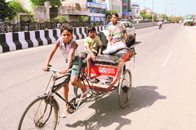 A child pedals a rickshaw with other children as passengers on Goniana road in the city on Sunday. 