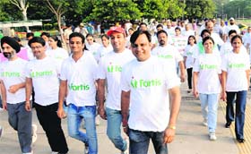 People take part in a walkathon at the Sukhna Lake to mark World Physiotherapy Day