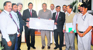 RK Dubey, Chairman of Canara Bank, presents a cheque for Rs 5.28 crore as disaster relief to Uttarakhand CM Vijay Bahuguna in Dehradun on Sunday.