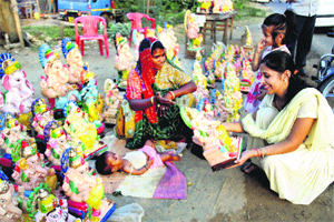 A woman buys a Ganesha idol from a vendor at Sukhpura Chowk of Rohtak on Sunday on the eve of Ganesh Chaturthi.