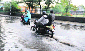 Motorcyclists wade through the flooded Residency Road in Srinagar on Sunday.
