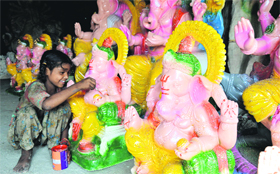 A girl gives final touches to an idol of Lord Ganesha ahead of Ganesh Chaturthi in Ludhiana.
