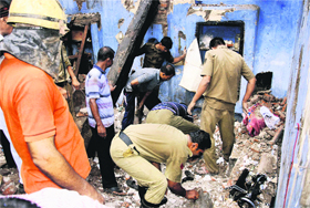 Rescue officials search for survivors at the scene of a building collapse in Puri on Sunday.