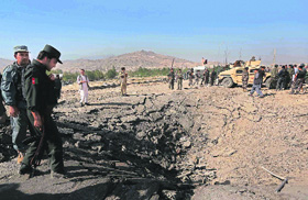 4 Afghan intel agents dead in suicide attack: Policemen stand near a crater at the scene of a suicide attack in Maidan Shar, capital of Wardak province, on Sunday. At least four Afghan intelligence agents were killed and more than 100 persons were wounded. All five suicide attackers involved have been killed by security forces.
