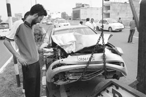 A man looks at the mangled remains of a car hit by a tempo on the Panchkula-Zirakpur highway on Monday. No one was hurt in the mishap.
