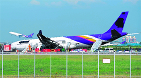 A Thai Airways plane rests on the ground after it skidded off the runway at Bangkok airport on Monday.