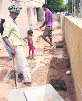 A temporary measure, labourers fill another pit with soil, inviting another mishap, at Sector 32, Chandigarh.